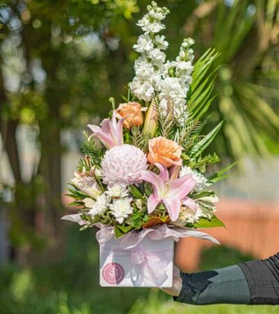 pastel posy box Vibrant floral arrangement with lilies, roses, and chrysanthemums in a pink wrapping, perfect for special occasions.