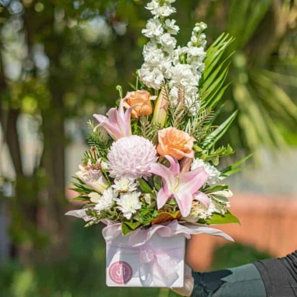 Vibrant floral arrangement with lilies, roses, and chrysanthemums in a pink wrapping, perfect for special occasions.