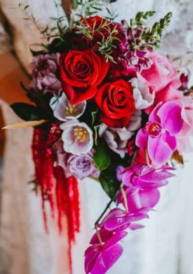 modern wedding bouquet Vibrant floral bouquet featuring red roses, pink orchids, and white blossoms for special occasions.