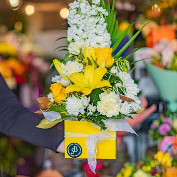 Vibrant fresh flower arrangement featuring white, yellow, and green blossoms for special occasions.