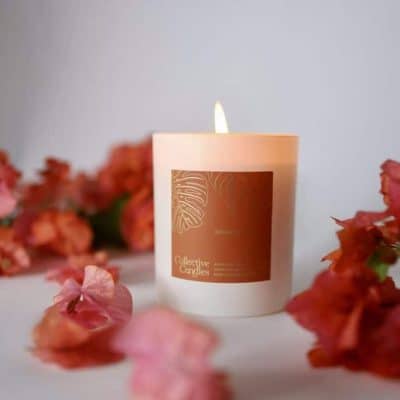 Soft pink floral candle with petals and blooms, perfect for home decor and relaxing ambiance.