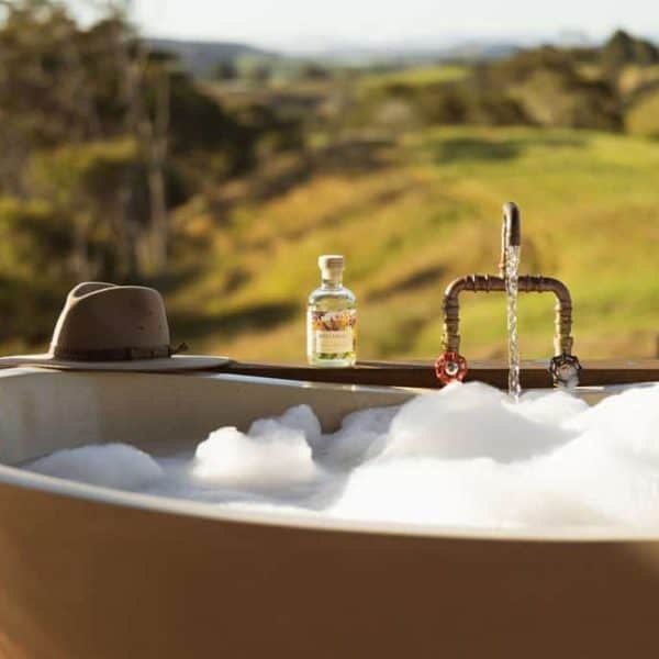 citrus flower and water mint bubble bath 2 Outdoor spa bathtub with scenic rural landscape in New Zealand, ideal for relaxing retreats.