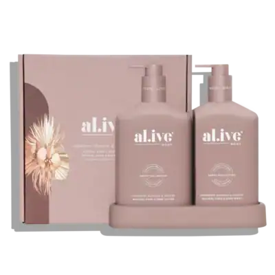 Creamy pink raspberry blossom and juniper hand and body lotion set on light pink background.