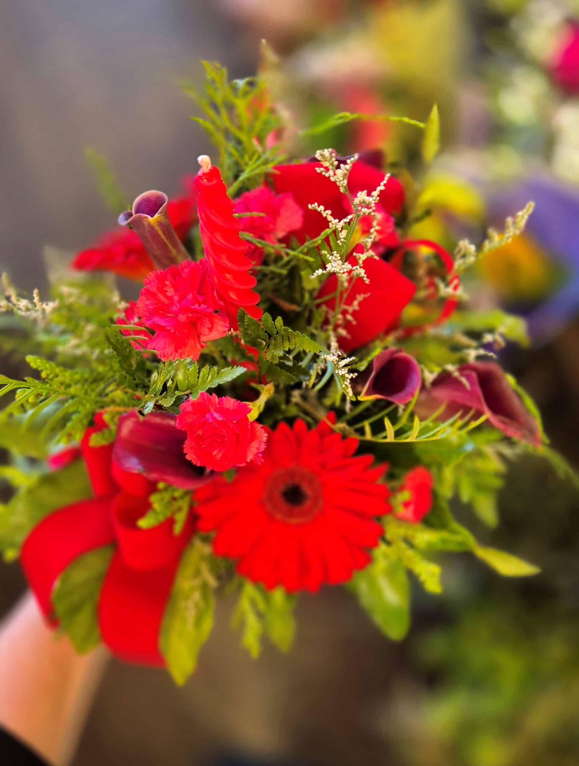 Vibrant red floral bouquet with various blooms and greenery, perfect for gifting or decoration.