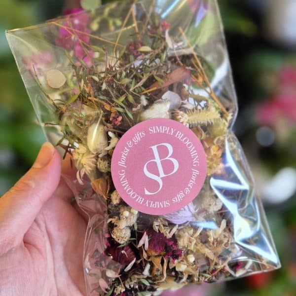 Dried flower and herb bouquet in clear wrapping with Simply Blooming pink logo tag.