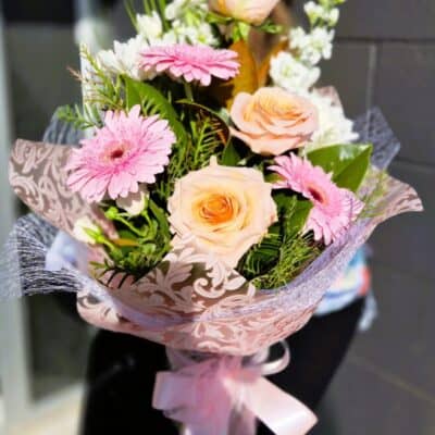 1. pastel vase of flowers 2 Pink and peach flower bouquet with roses and gerbera daisies, wrapped in decorative paper.