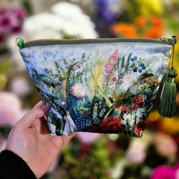 Colourful floral embroidery on fabric zip pouch with green tassel, ideal for storage or gift.