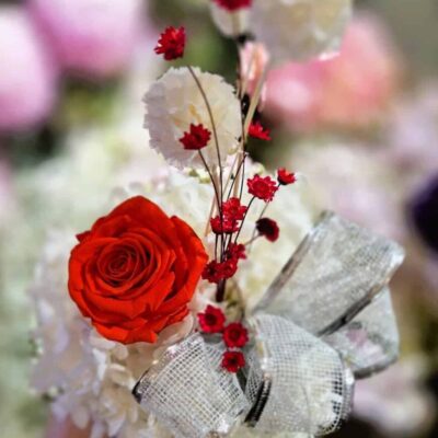 Fresh floral arrangement with roses and delicate blooms for special occasions. Beautiful bouquet featuring vibrant roses and soft white flowers with a decorative bow.