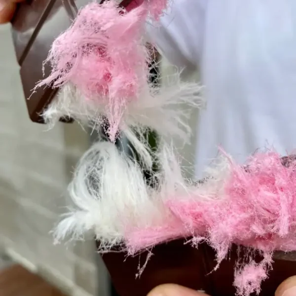 Pink and white fluffy yarn for knitting or crafting.