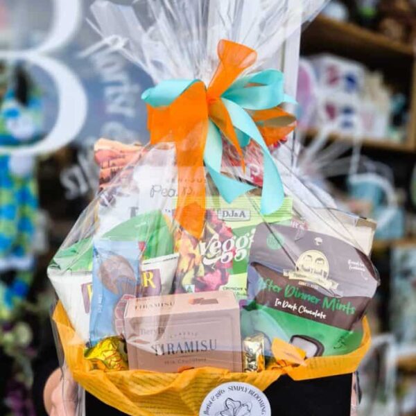 Vibrant gift basket featuring fresh flowers, assorted chocolates, and snacks, perfect for celebrations or gifting purposes.