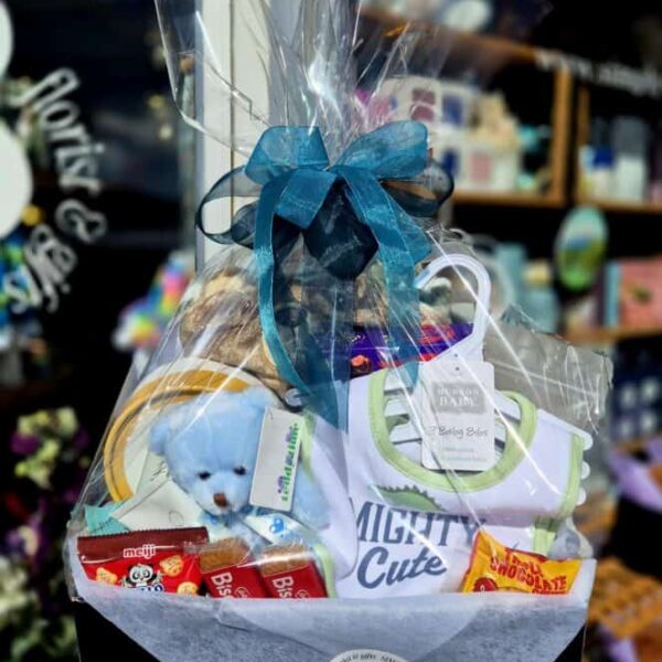 A charming gift basket featuring a plush teddy, snacks, and baby items, perfect for celebrating a child's special occasion.