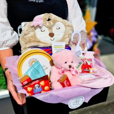 Cute plush bear with floral-themed gifts and treats.