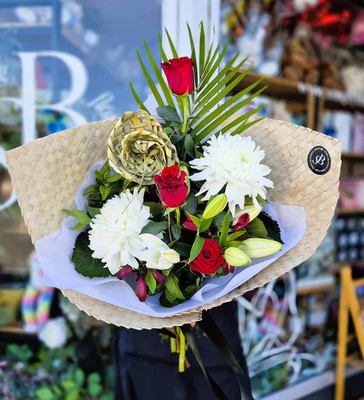 Beautiful bouquet featuring red roses, white lilies, and greenery, perfect for celebrations or gifti.
