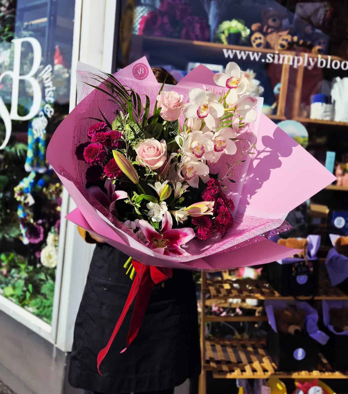 Beautiful orchid and rose bouquet wrapped in pink for special occasions.