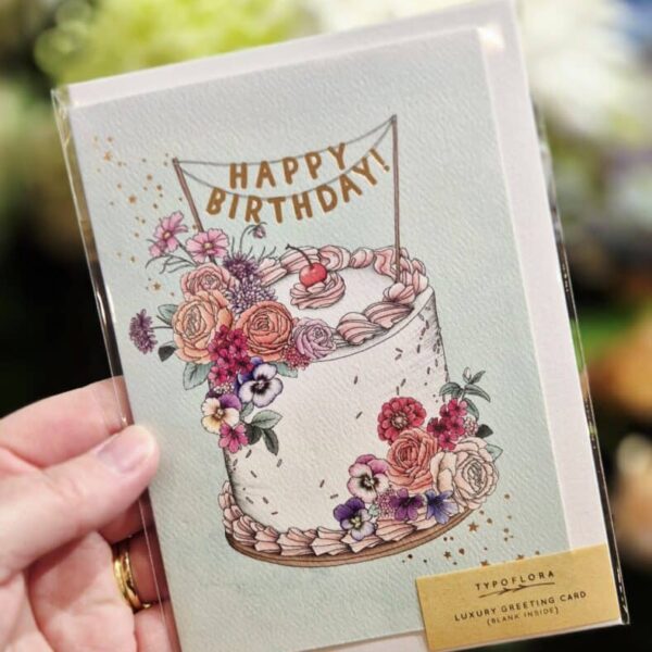 Elegant birthday greeting card featuring a floral cake design and festive banner for special celebrations.
