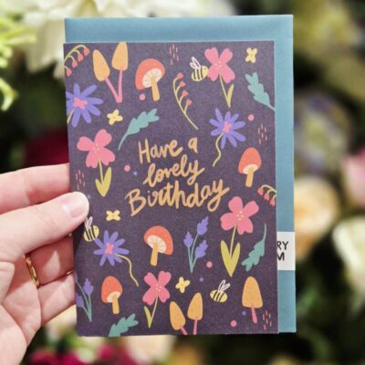 Colorful floral and mushroom-themed birthday card with cheerful message.
