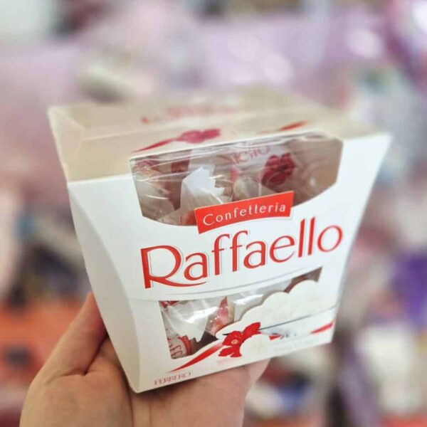 Hand holding a Raffaello chocolate box, showcasing the packaging.