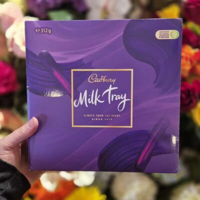 Cadbury Milk Tray chocolate box in purple packaging with gold accents.
