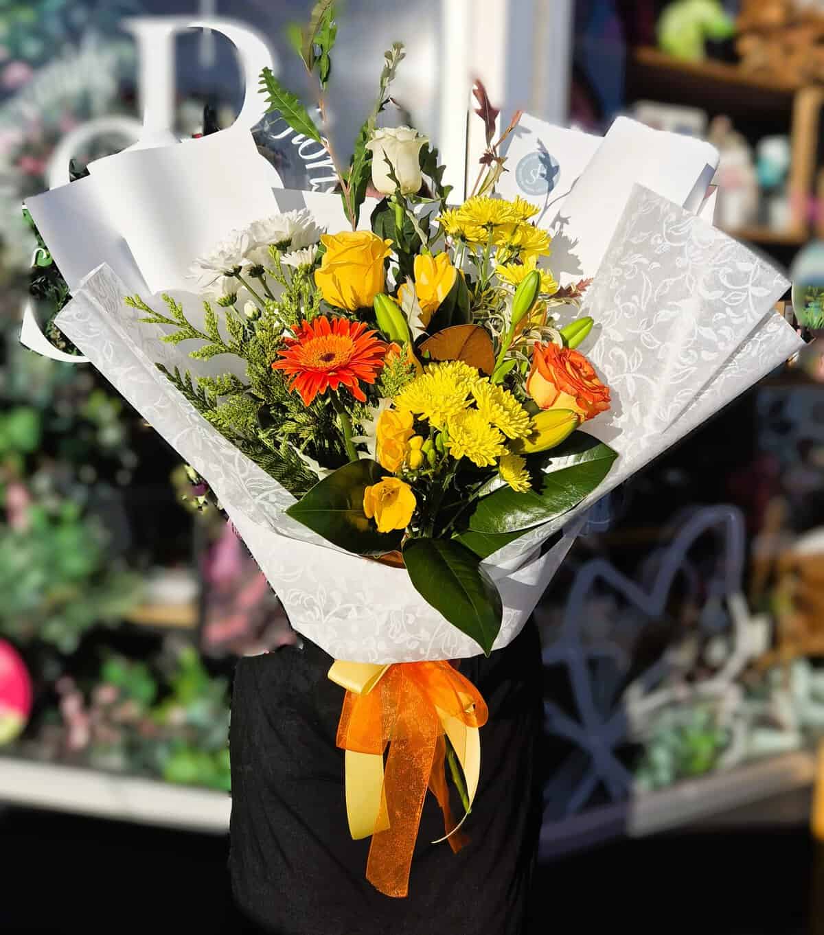 Vibrant mixed flower bouquet with roses, daisies, and greenery, perfect for celebrations and gifting.