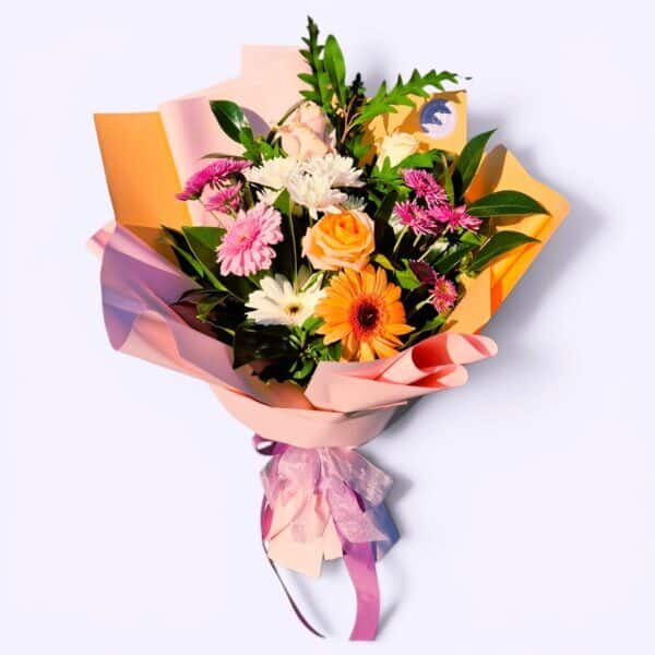 A vibrant mixed flower bouquet featuring roses, daisies, and greenery, wrapped in pastel paper with.